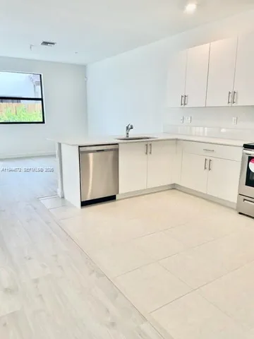 a view of kitchen with white cabinets