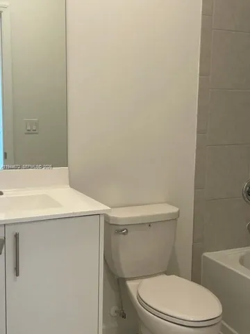 a white toilet sitting next to a white sink