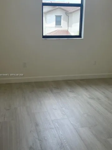 a view of a small space with wooden floor and a window