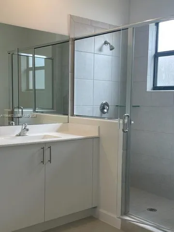 a bathroom with a shower sink and mirror