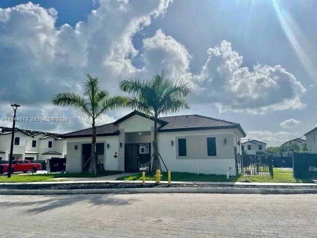 a front view of a house with a garden and plants