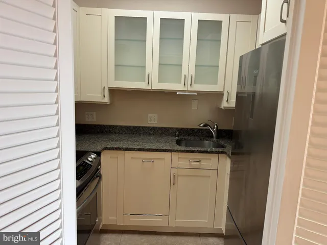 a kitchen with granite countertop white cabinets and a stove
