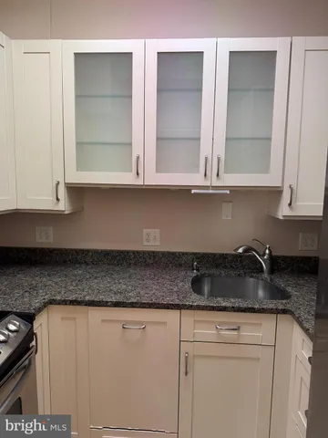 a view of a kitchen with granite countertop white cabinets