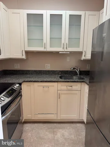 a kitchen with granite countertop white cabinets and a sink