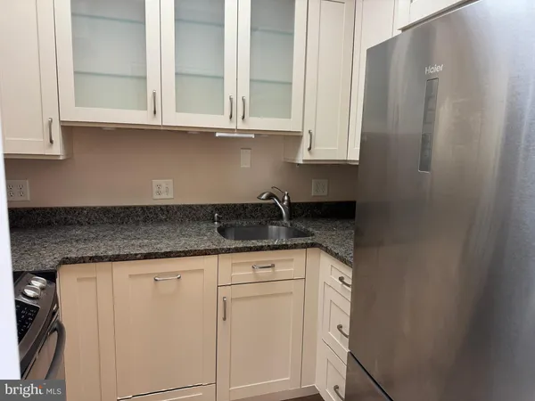 a kitchen with granite countertop white cabinets and stainless steel appliances