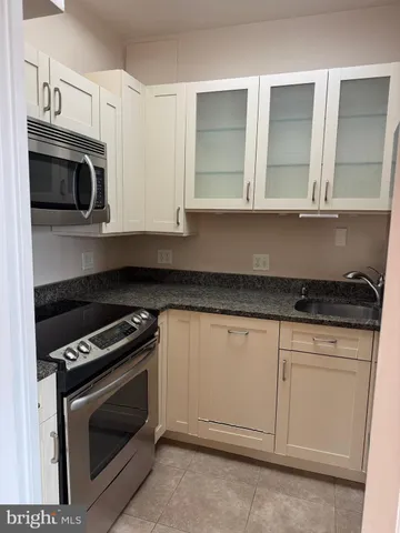a kitchen with granite countertop white cabinets stainless steel appliances and sink
