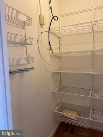 a view of a closet with wooden floor