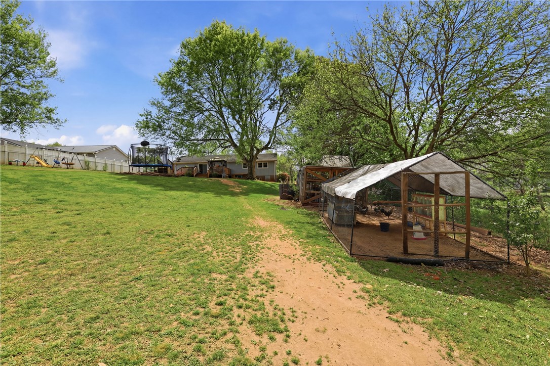 904 New Prospect Church Road Anderson, SC 29625 - Photo 27 of 31 Expansive backyard with verdant lawn and mature trees perfect for outdoor living.