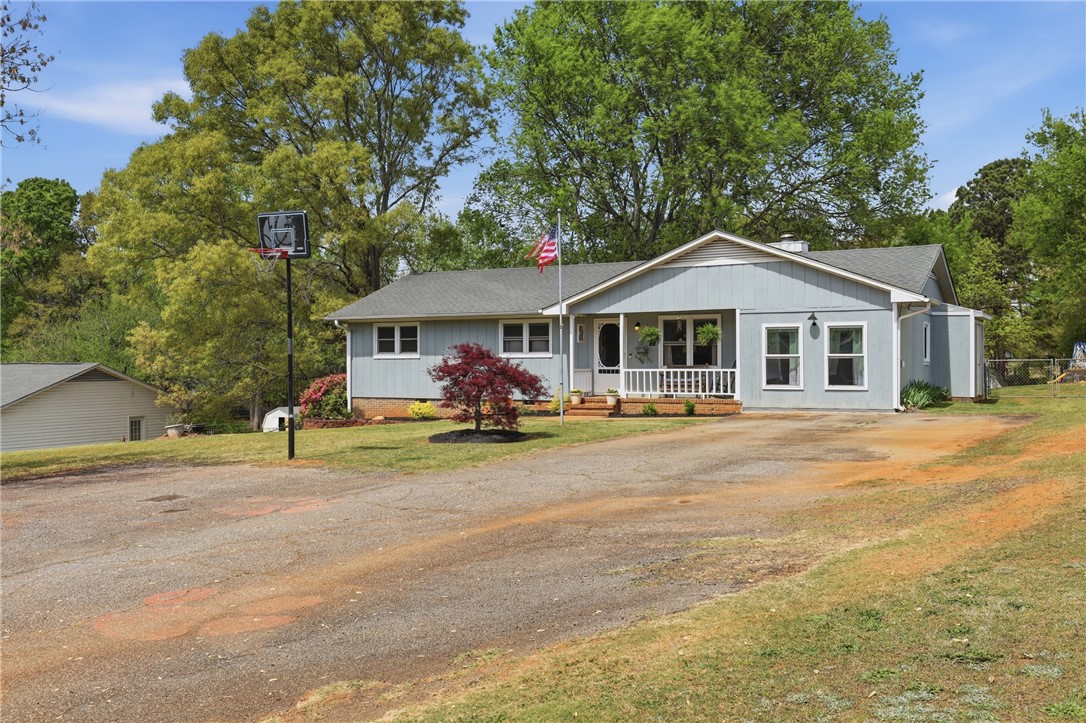 904 New Prospect Church Road Anderson, SC 29625 - Photo 29 of 31 A charming residence featuring a welcoming porch, lush greenery, and expansive grounds.