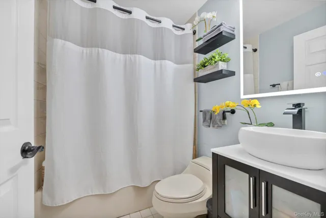 a white toilet sitting next to a bathroom sink and a tub
