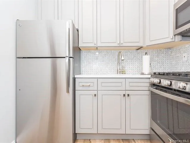 a kitchen with stainless steel appliances granite countertop a refrigerator and a sink