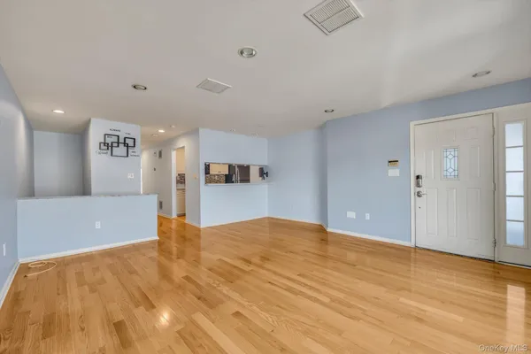 a view of a big room with wooden floor and a kitchen