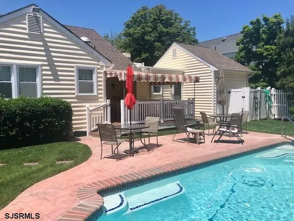 a view of a house with backyard and sitting area