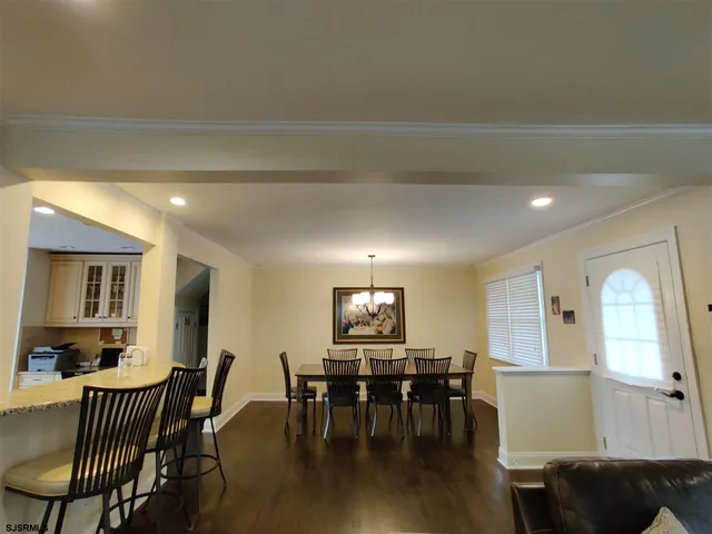 a view of a a dining room with furniture window and wooden floor