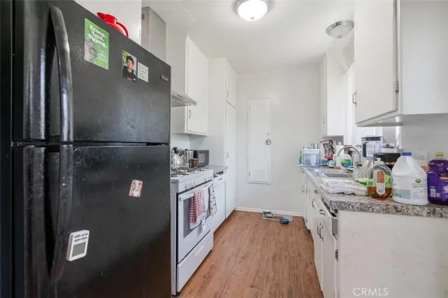 a kitchen with granite countertop a refrigerator and a sink