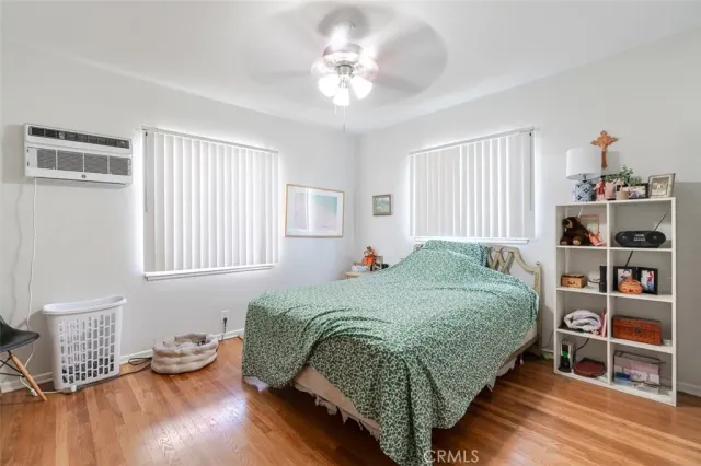 a bedroom with a bed and a wooden floor