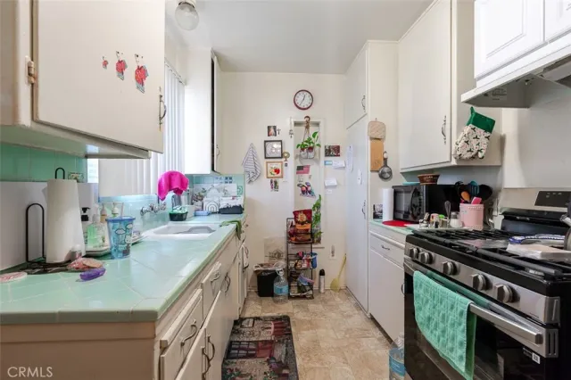 a kitchen with granite countertop a sink stove and cabinets