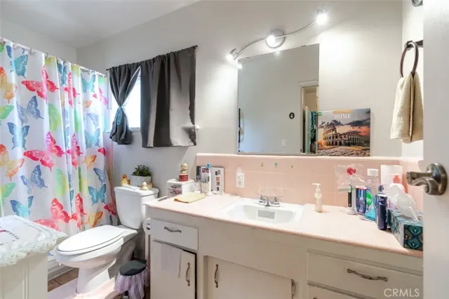 a bathroom with a sink vanity mirror and toilet