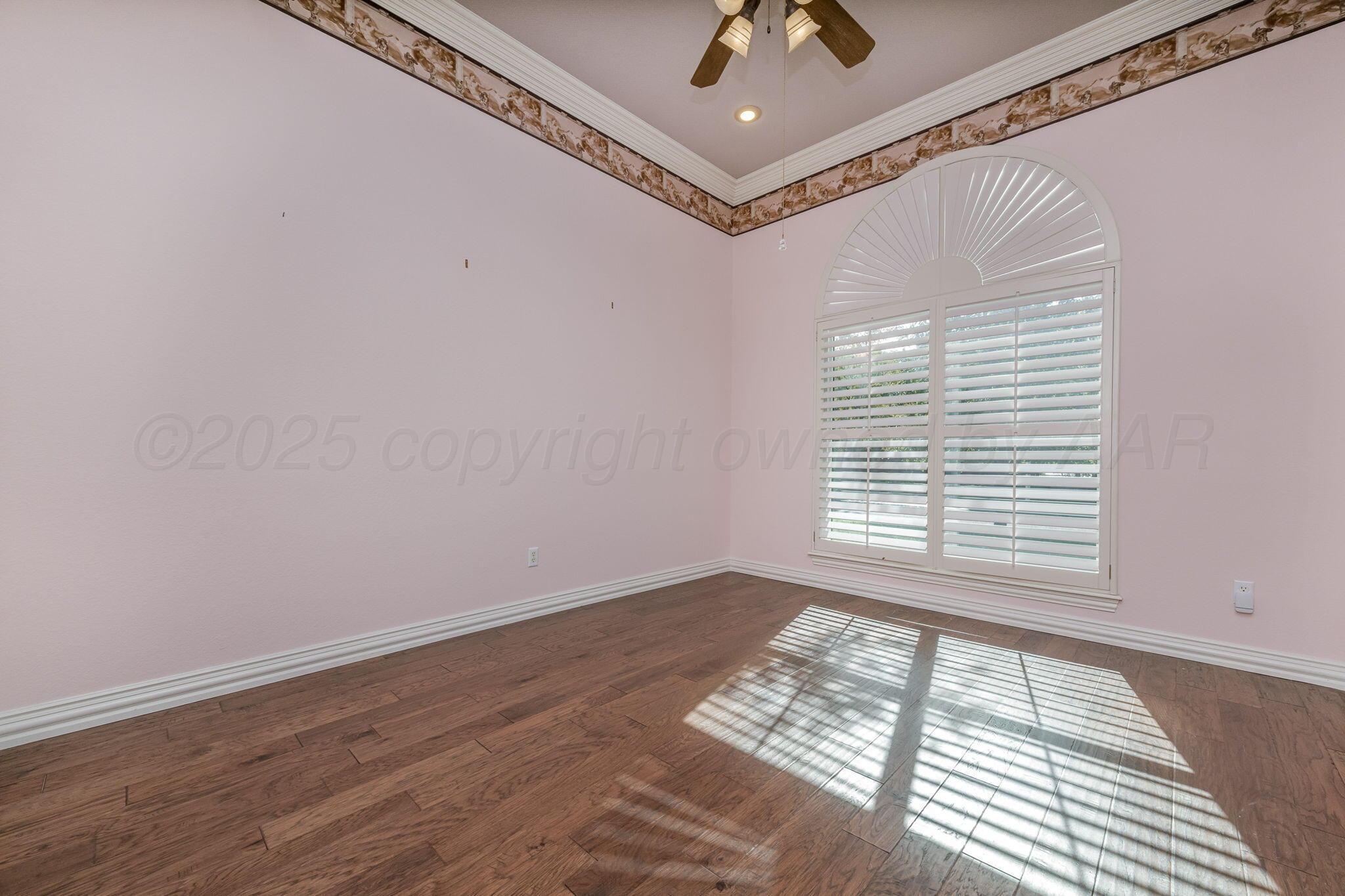 7408 Park Ridge Drive Amarillo, TX 79119 - Photo 18 of 51 a view of an empty room with a window and wooden floor