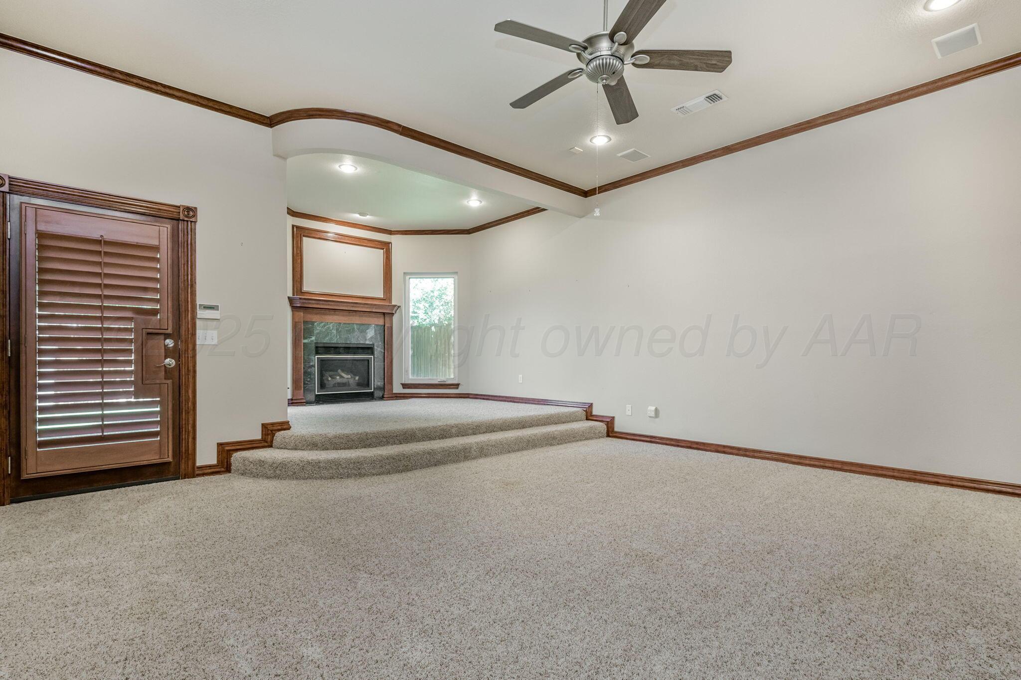7408 Park Ridge Drive Amarillo, TX 79119 - Photo 21 of 51 a view of an empty room with a fireplace and a window