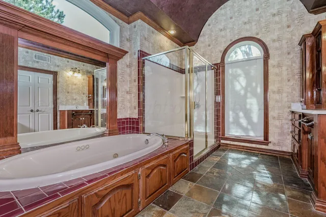 a bathroom with a bathtub and a large mirror