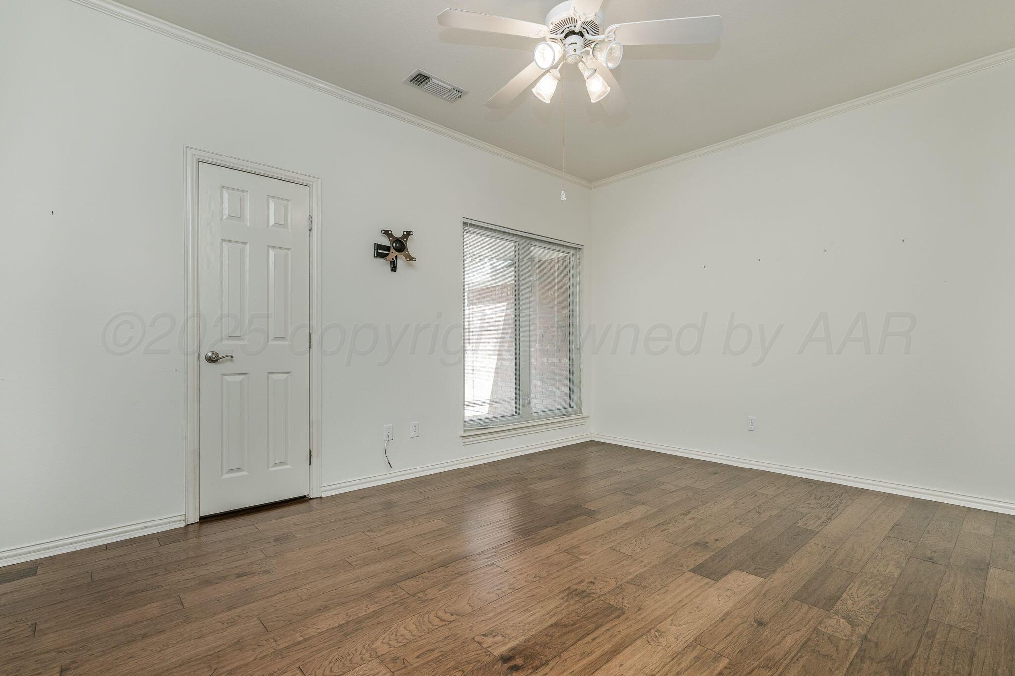 7408 Park Ridge Drive Amarillo, TX 79119 - Photo 32 of 51 a view of an empty room with wooden floor and a window