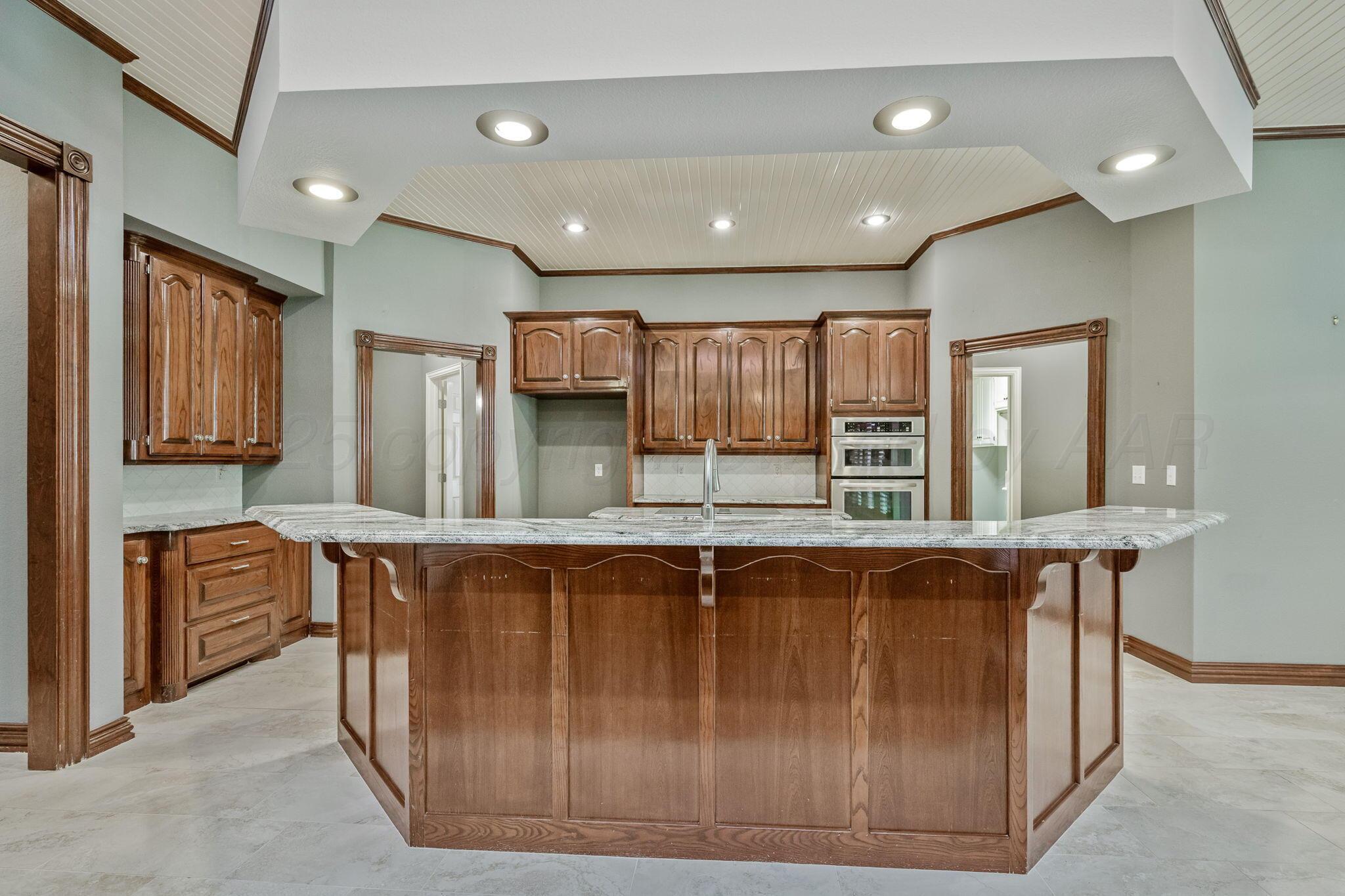 7408 Park Ridge Drive Amarillo, TX 79119 - Photo 4 of 51 a large kitchen with stainless steel appliances granite countertop a stove and a sink