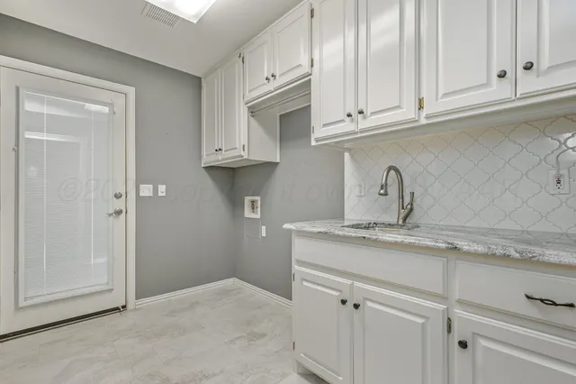 a kitchen with stainless steel appliances granite countertop white cabinets and a sink