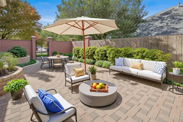 a view of a patio with couches table and chairs under an umbrella