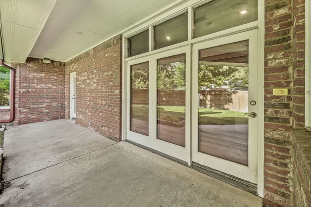 a view of a backyard with large trees and wooden fence
