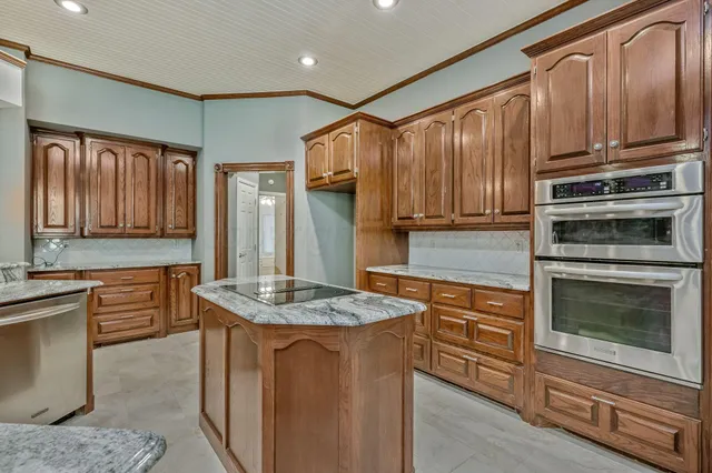 a kitchen with stainless steel appliances granite countertop a stove refrigerator sink and cabinets