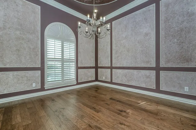 a view of a livingroom with wooden floor and a large window