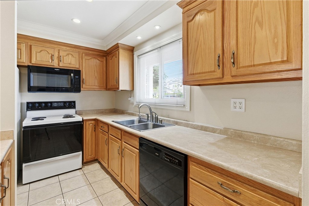 3342 Bradbury Road, Unit 20 Los Alamitos, CA 90720 - Photo 12 of 32 a kitchen with stainless steel appliances granite countertop a sink stove and microwave