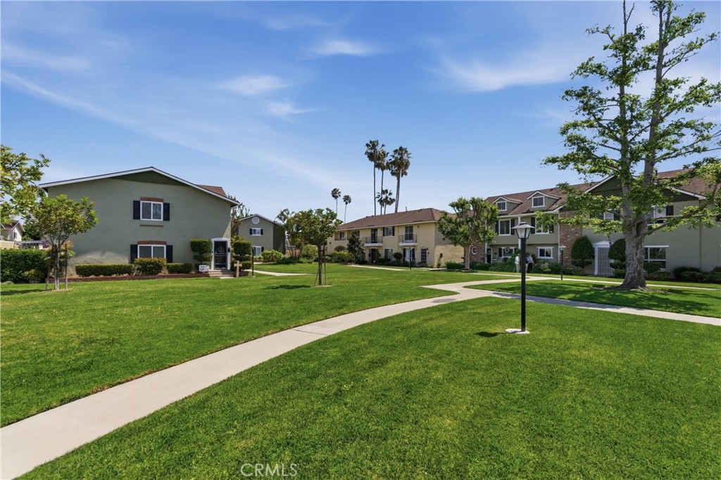 3342 Bradbury Road, Unit 20 Los Alamitos, CA 90720 - Photo 32 of 32 a view of a house with a big yard and a large tree