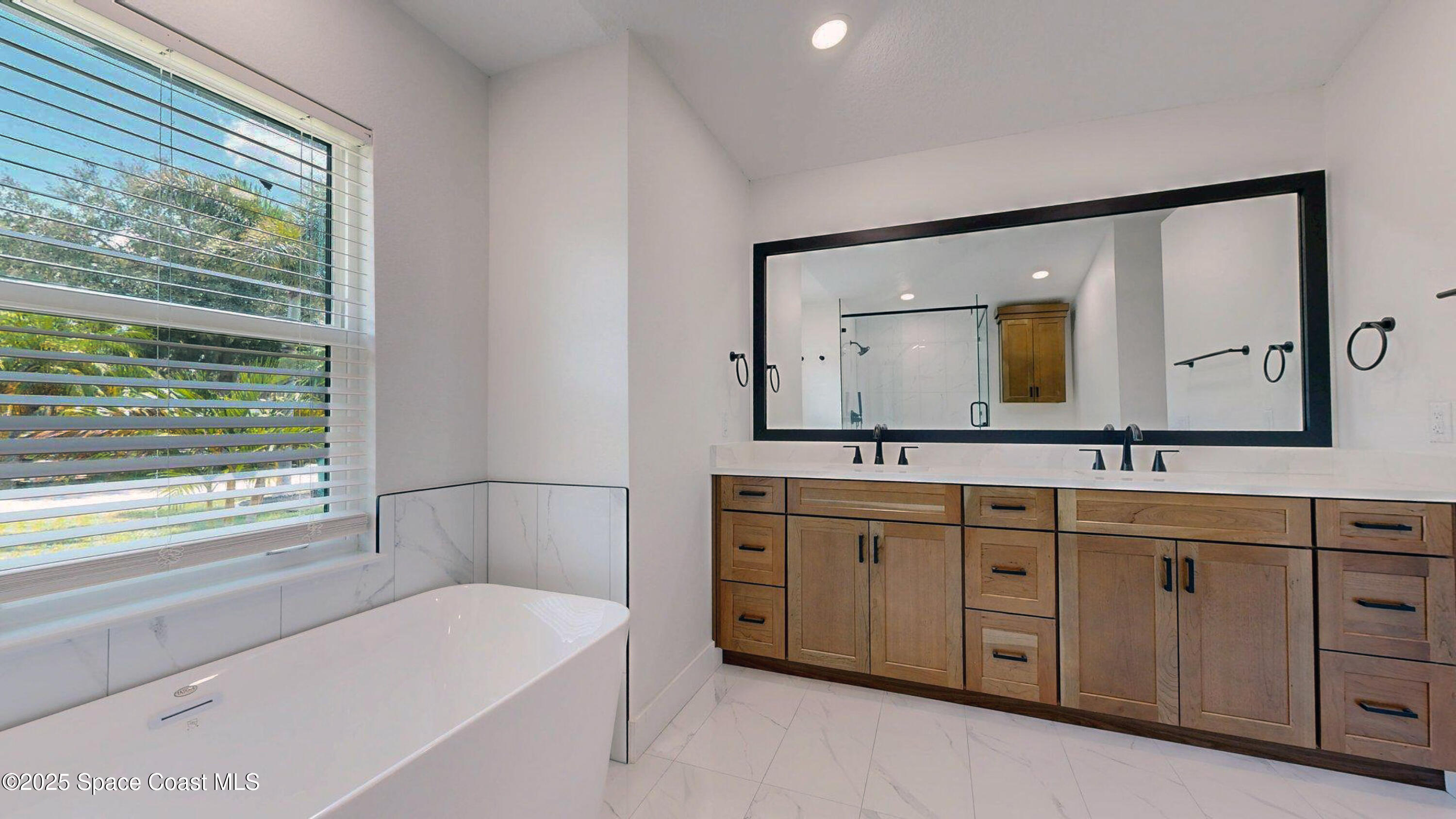 855 Cliftons Cove Court Cocoa, FL 32926 - Photo 57 of 72 a bathroom with a tub a double vanity sink and a large mirror