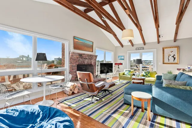 a living room with furniture fireplace and a large window
