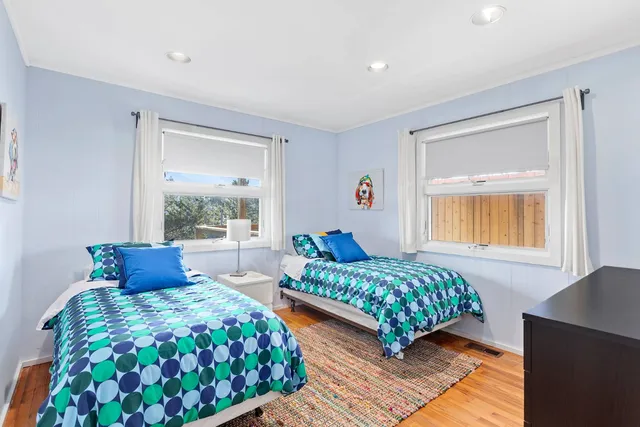 a bedroom with two beds and a window