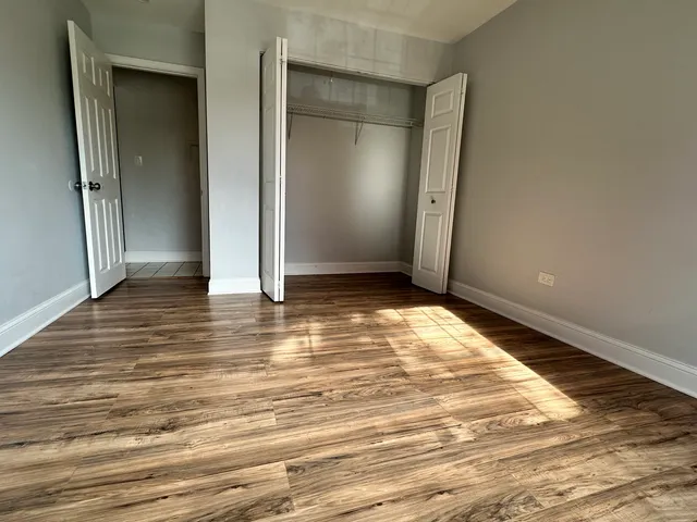 an empty room with wooden floor and entrance