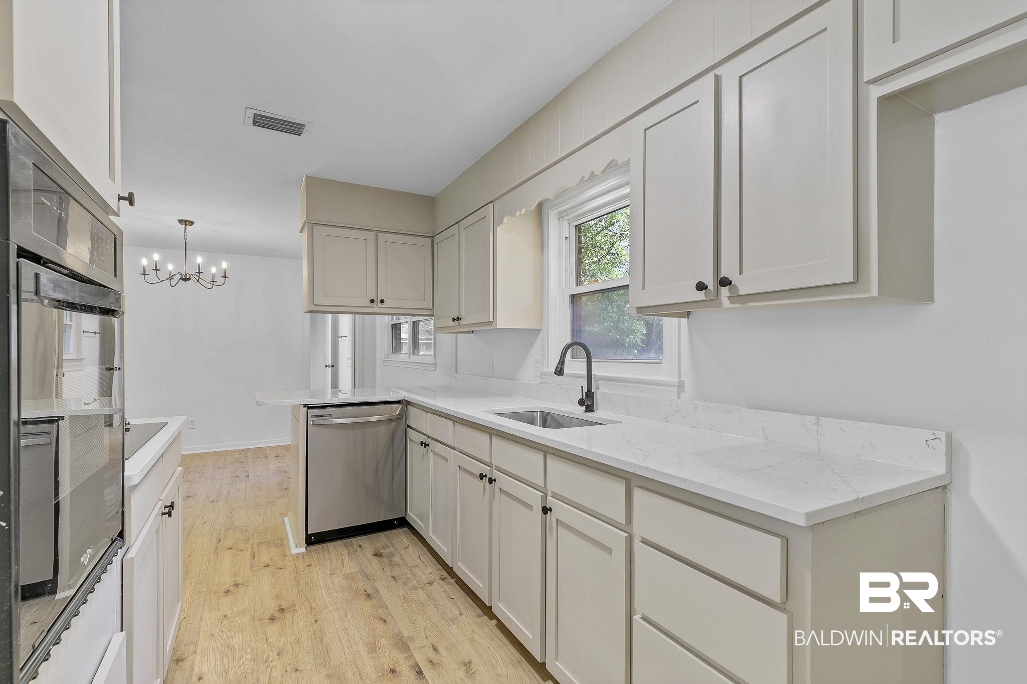 203 Anderson Road Saraland, AL 36571 - Photo 15 of 48 Kitchen featuring light wood-type flooring, visible vents, dishwasher, a sink, and a notable chandelier