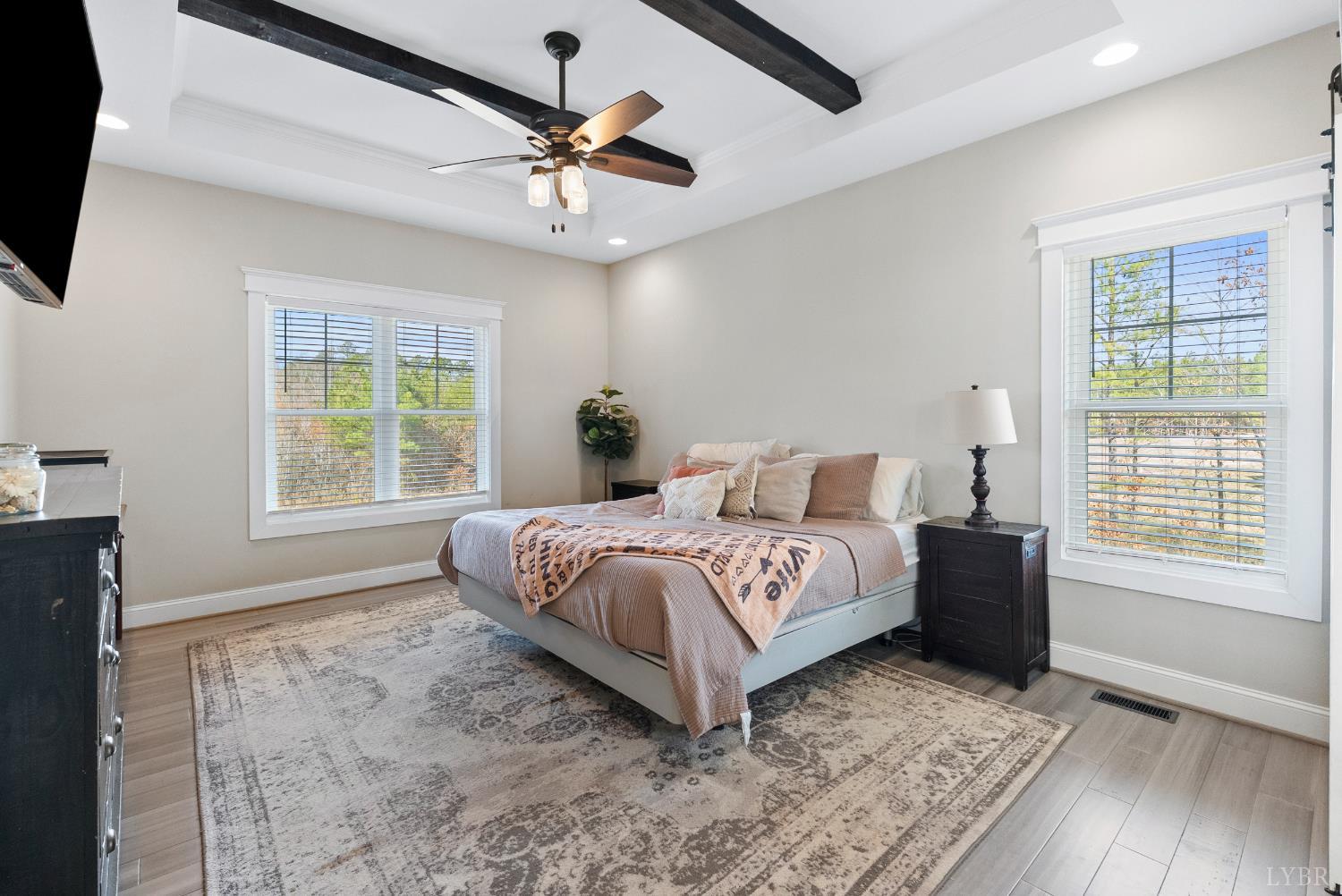 835 Sunset Ridge Drive Concord, VA 24538 - Photo 18 of 57 a spacious bedroom with a large bed a chandelier and windows