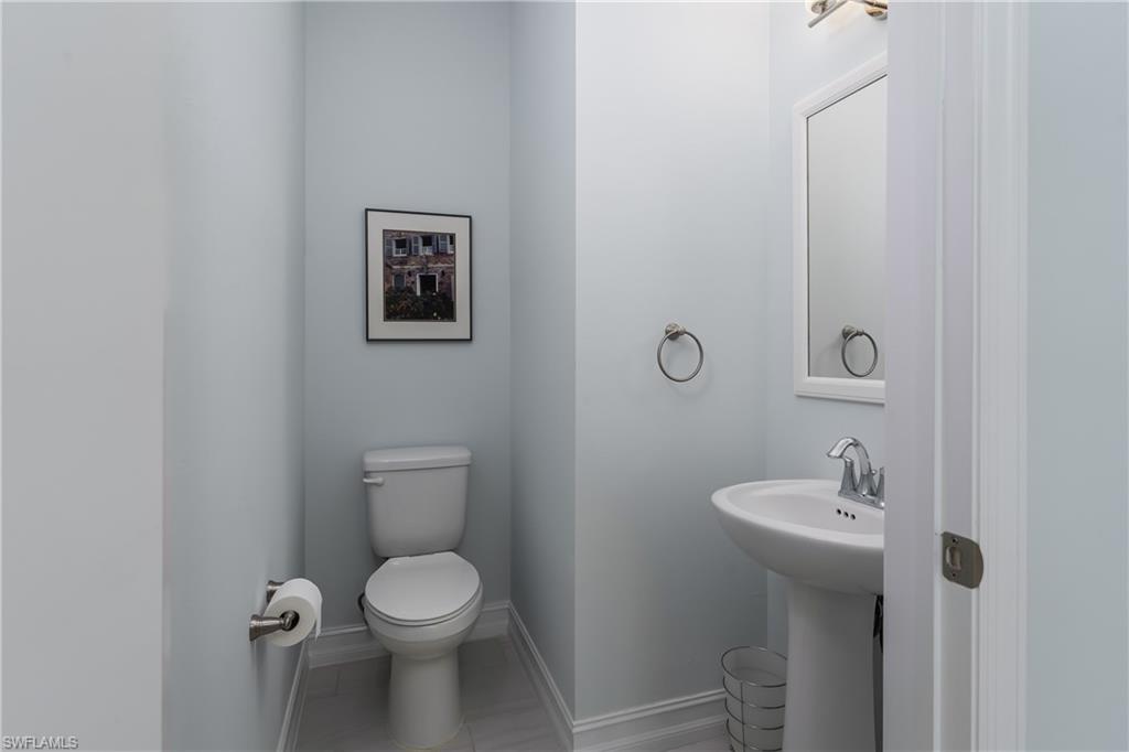 7336 Rockefeller Drive Naples, FL 34119 - Photo 11 of 50 a bathroom with a toilet sink and mirror