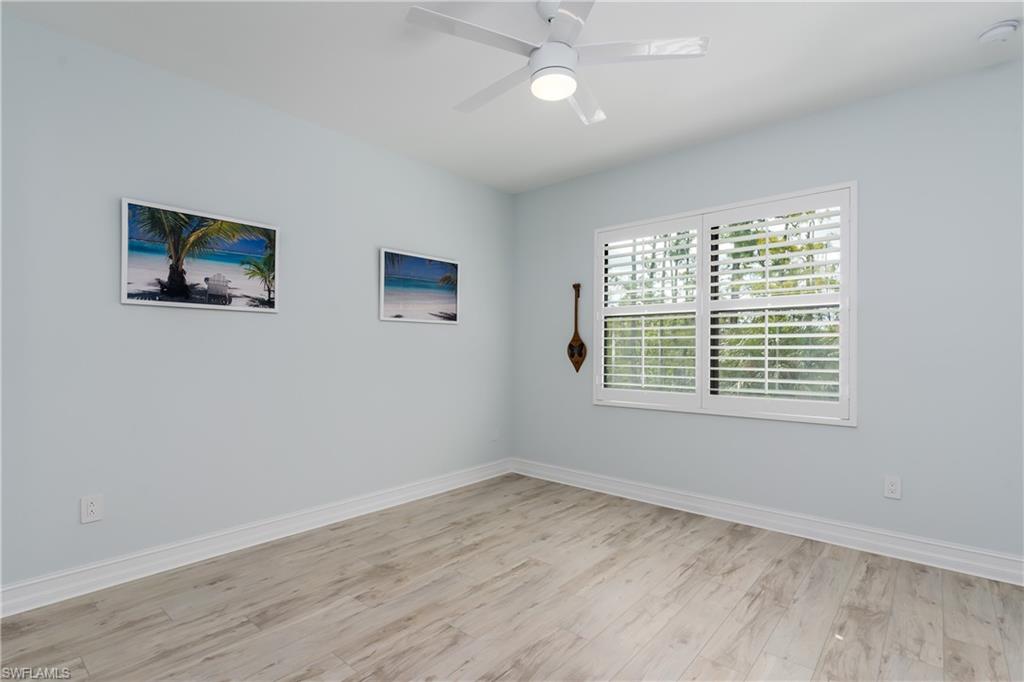 7336 Rockefeller Drive Naples, FL 34119 - Photo 17 of 50 a view of an empty room with a window and wooden floor