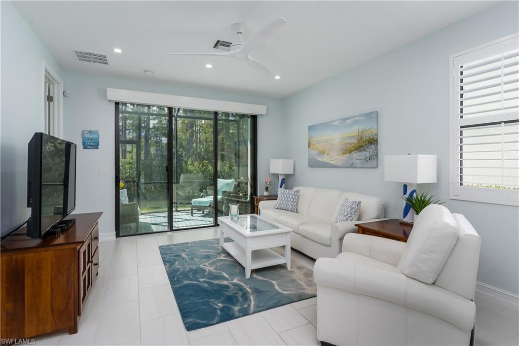 7336 Rockefeller Drive Naples, FL 34119 - Photo 4 of 50 a living room with furniture tv and a floor to ceiling window