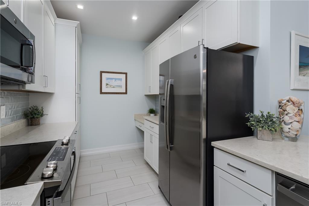 7336 Rockefeller Drive Naples, FL 34119 - Photo 8 of 50 a kitchen with stainless steel appliances a refrigerator and a stove