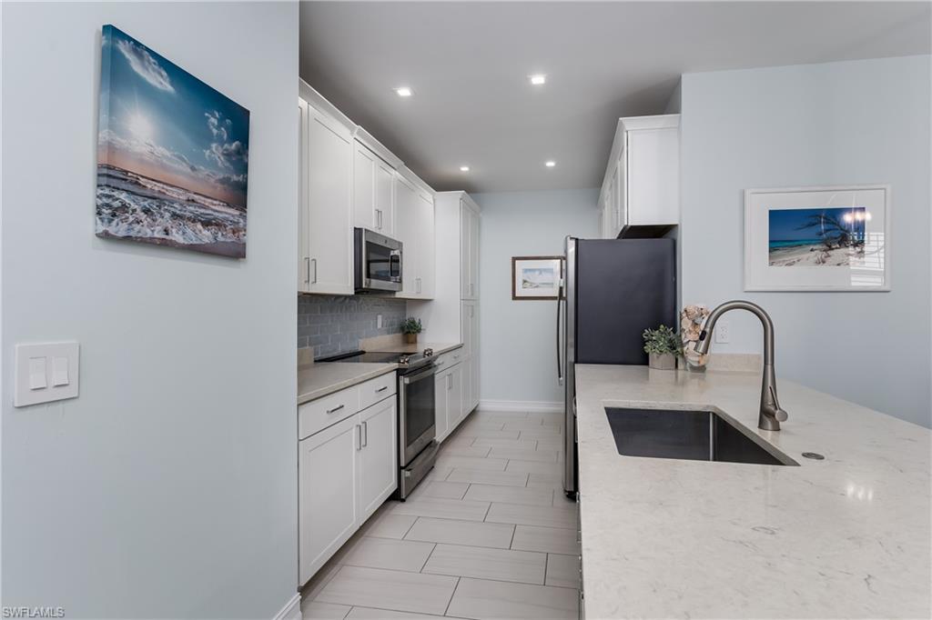 7336 Rockefeller Drive Naples, FL 34119 - Photo 9 of 50 a kitchen with stainless steel appliances granite countertop a refrigerator a stove top oven a sink and dishwasher