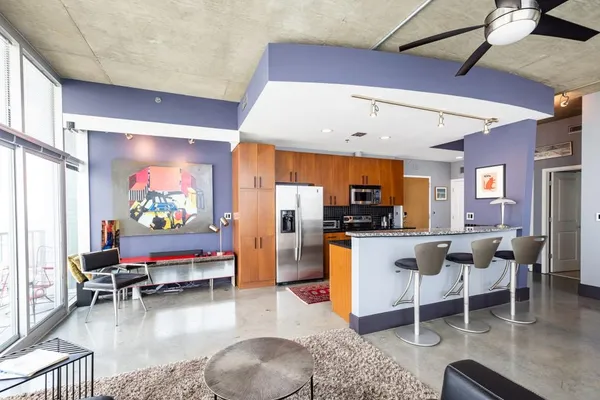 a kitchen with stainless steel appliances kitchen island granite countertop a sink and chairs