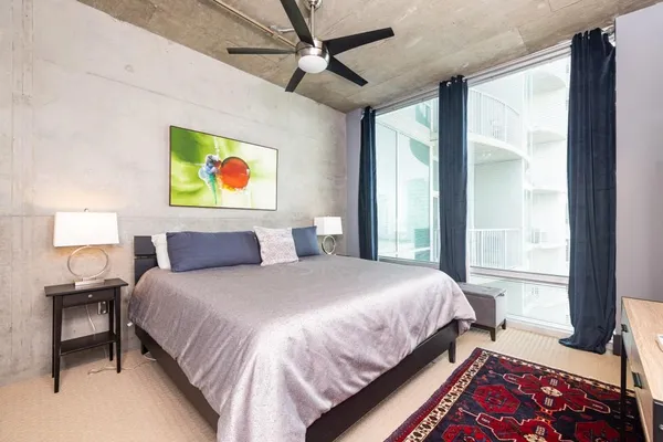 a bedroom with a bed and a painting on the wall
