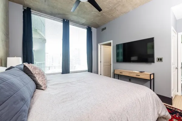 a bedroom with a bed and a flat screen tv