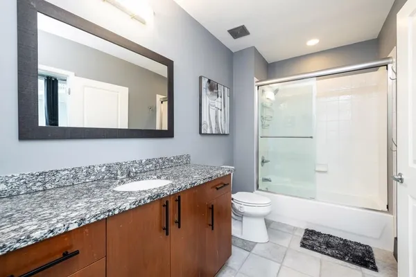 a en suite bathroom with a granite countertop sink and a mirror