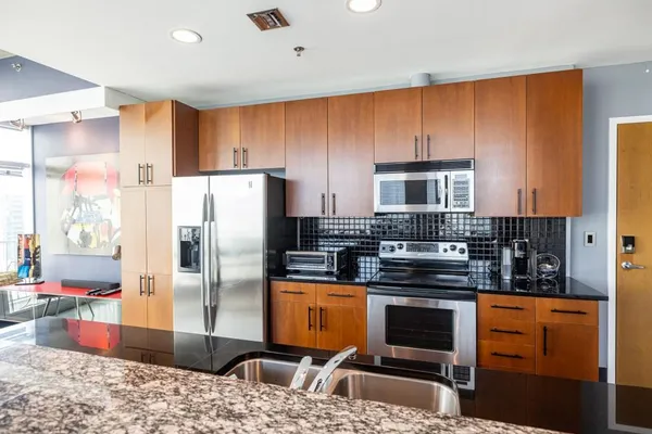 a kitchen with stainless steel appliances granite countertop a refrigerator stove and cabinets